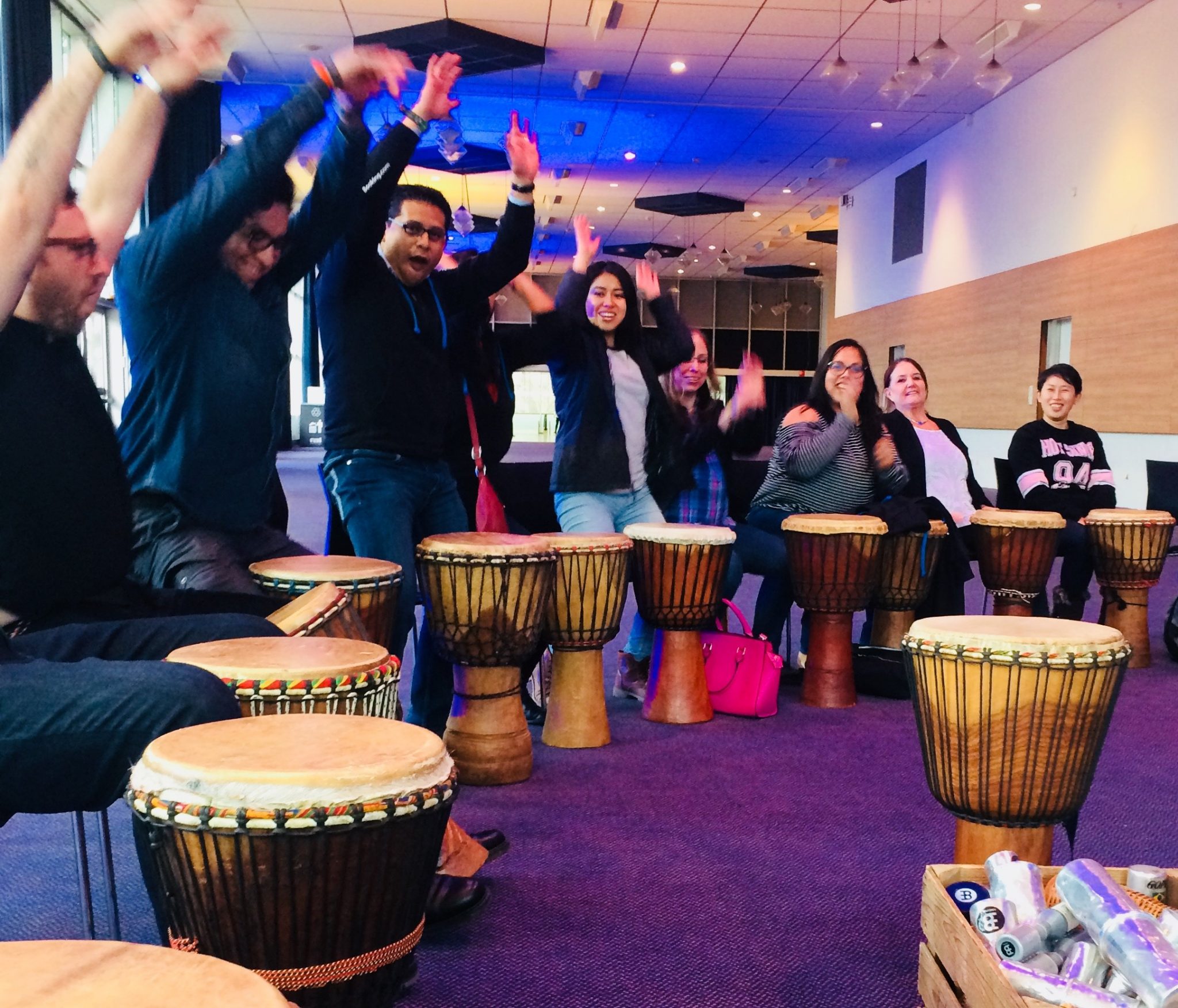Groep deelnemers tijdens een swingende workshop djembé met muzikanten van Dununba