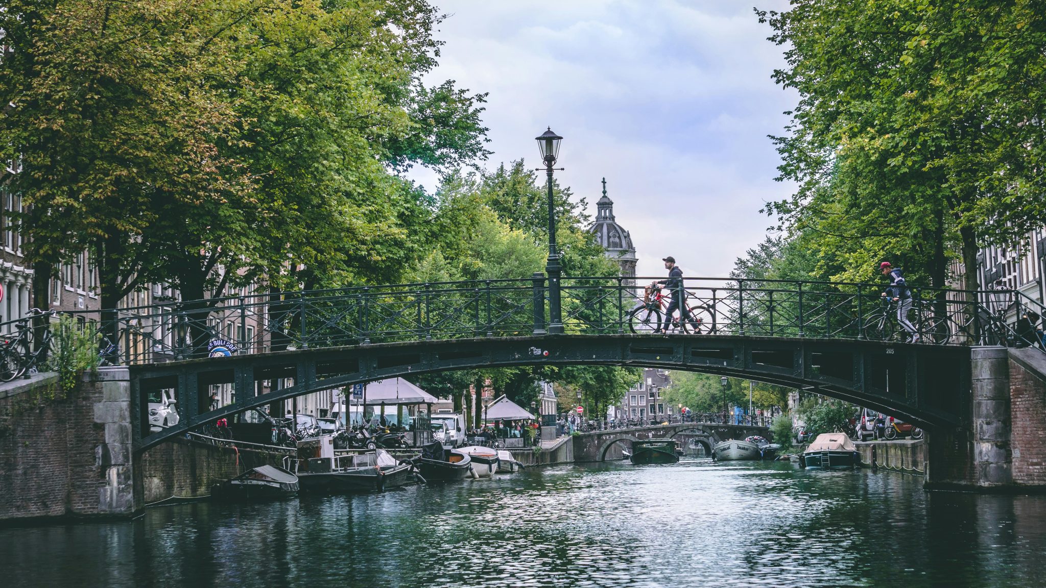 Pittoresk uitzicht op Amsterdamse grachten met historische gebouwen - een van de voordelen van wonen in Amsterdam